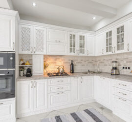 A bright kitchen with white cabinetry and floors.